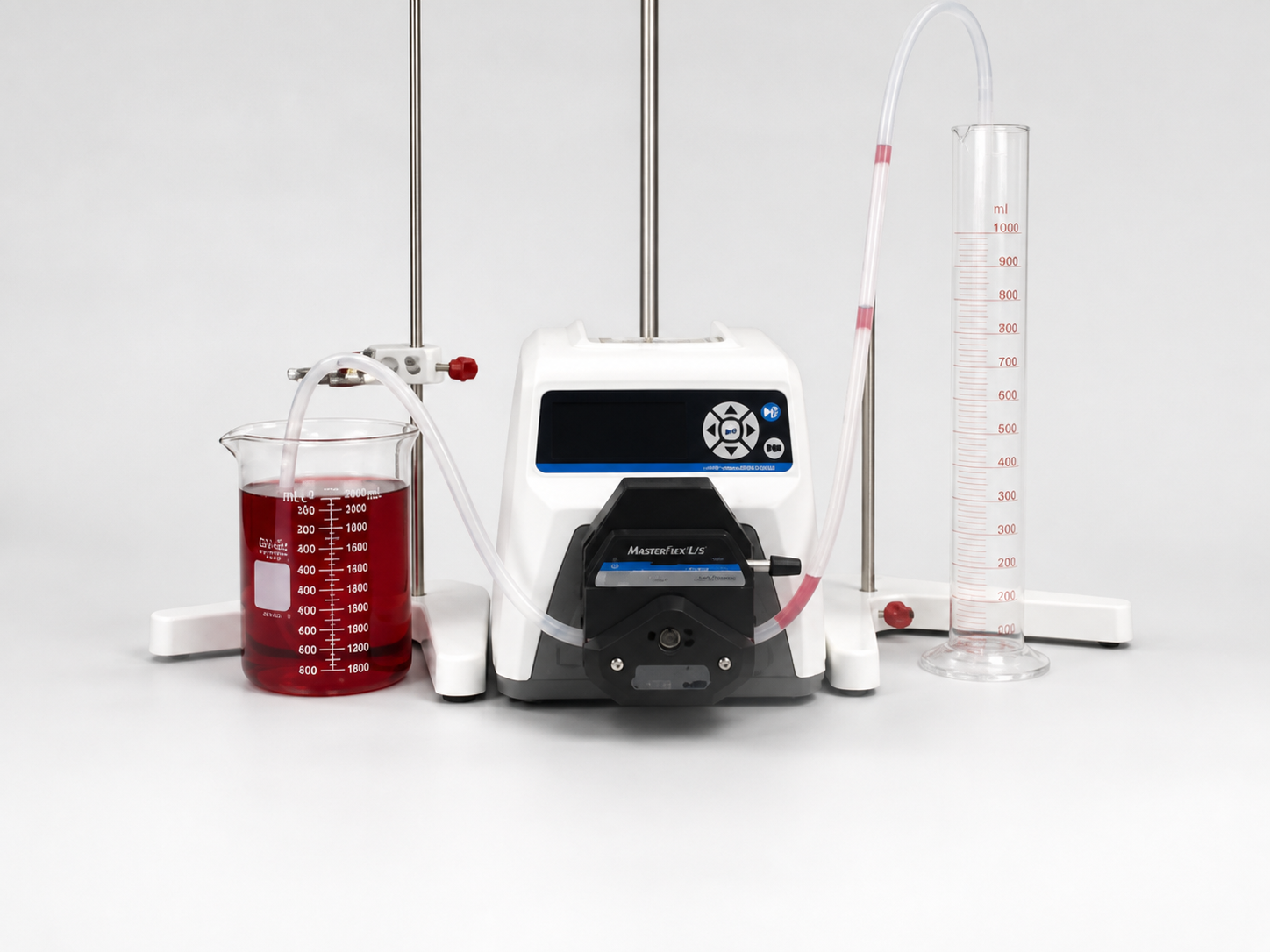 Calibration setup with a beaker of red dyed water, Masterflex pump head, tubing and a graduated cylinder on a lab bench