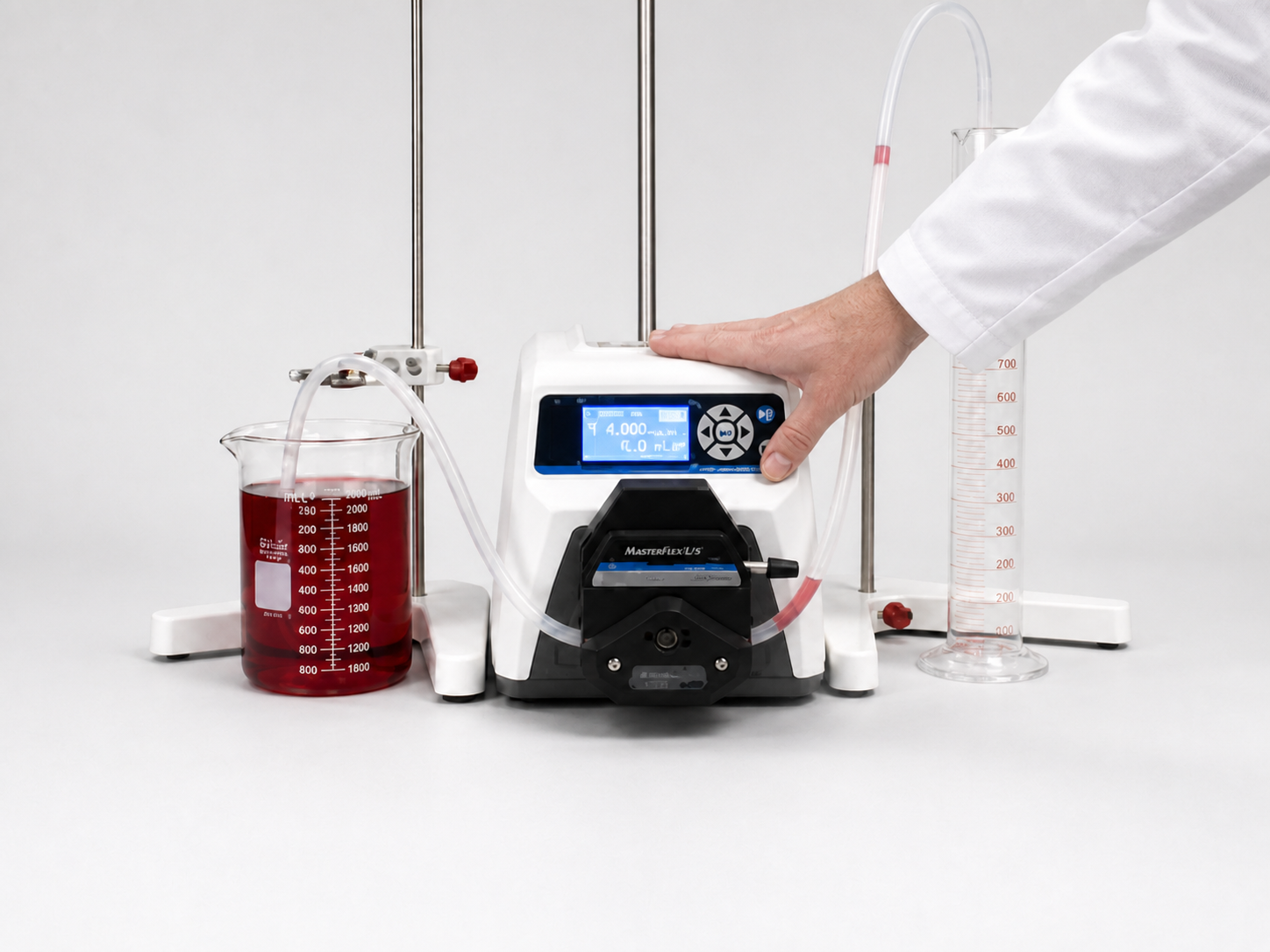 Hand pressing the prime key on the Masterflex L/S digital drive while water moves through the tubing